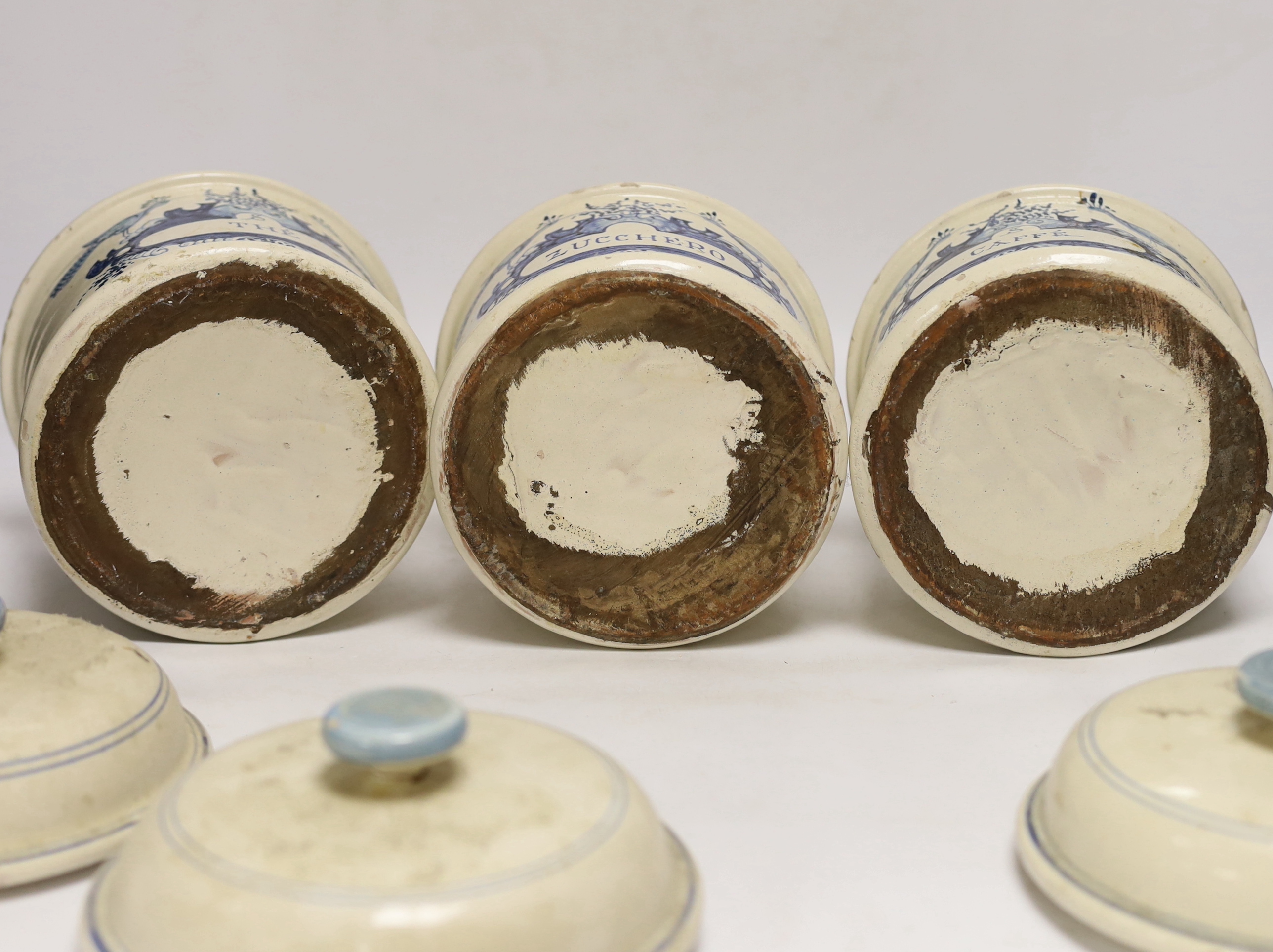 Three French cream and blue glazed storage jars and covers, Caffé, Thé and Zucchero, 18cm high